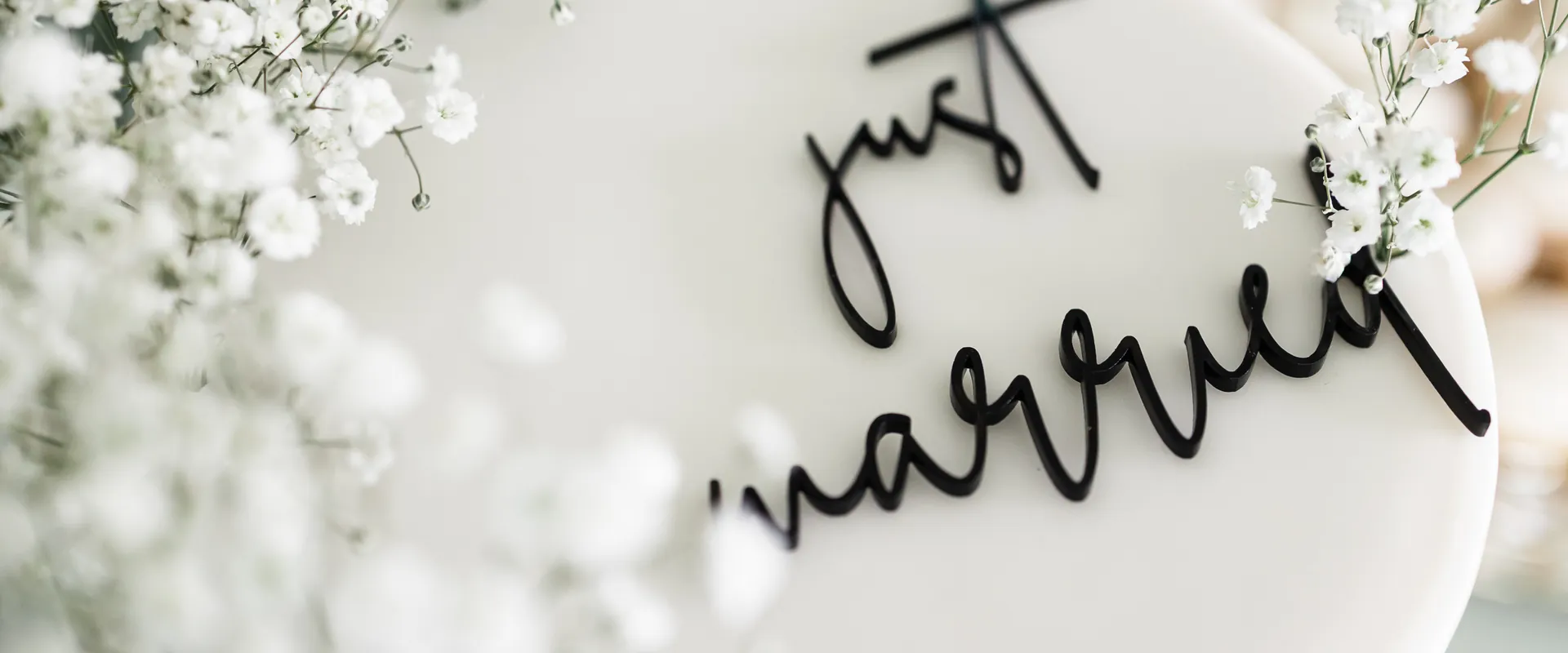 Detalle de letrero "Just Married" entre flores blancas
